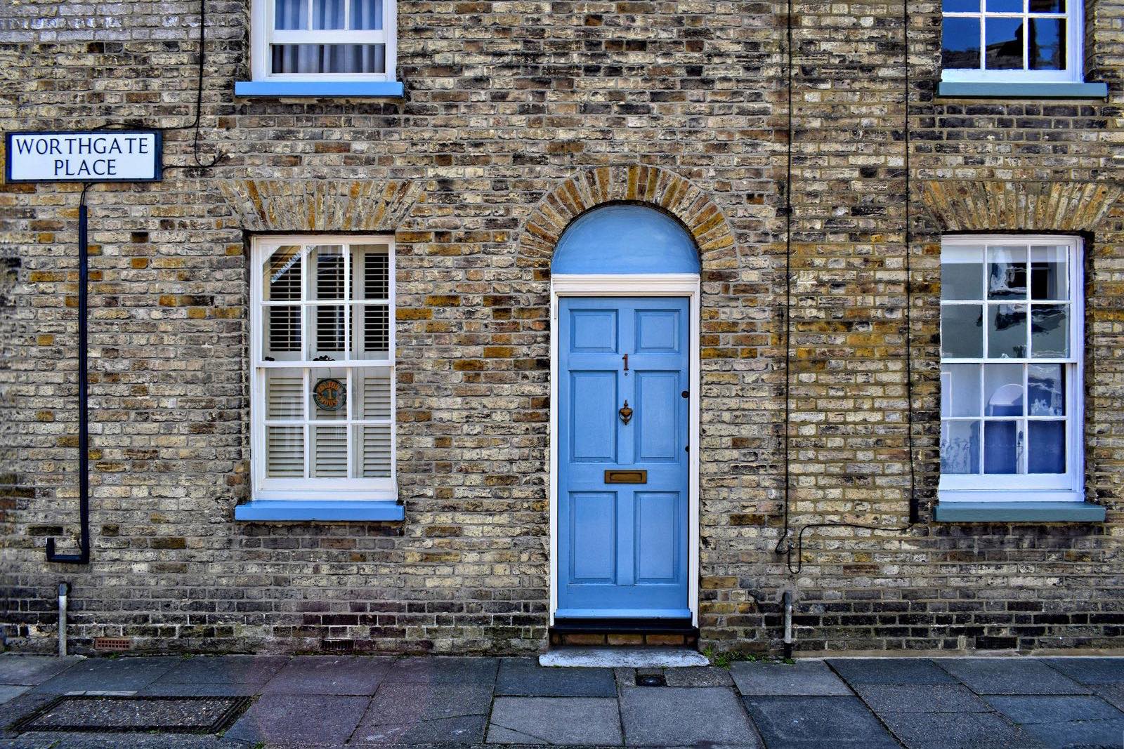 A blue front door on a UK brick terrace