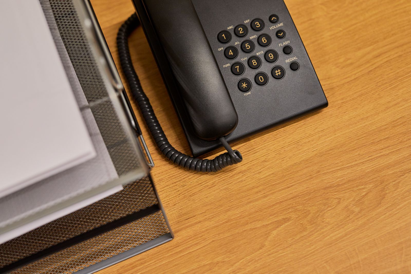 A desk telephone with the handset off its cradle