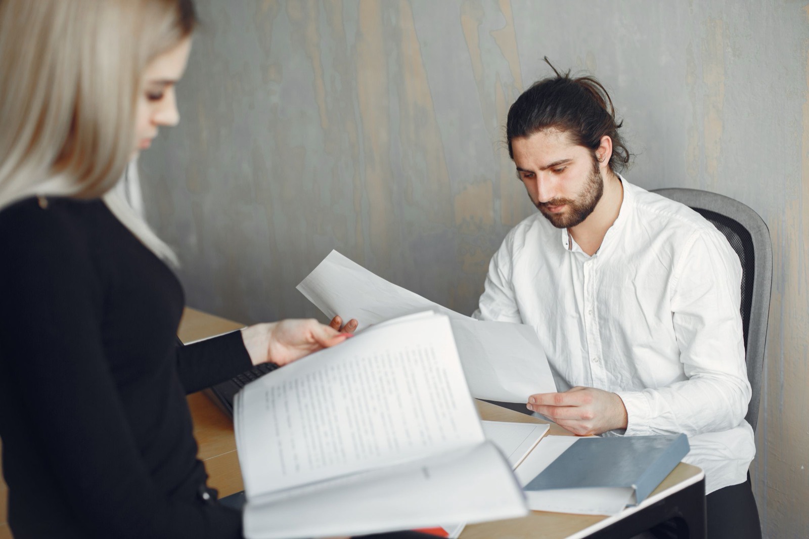 Two colleagues going over the same printed pages