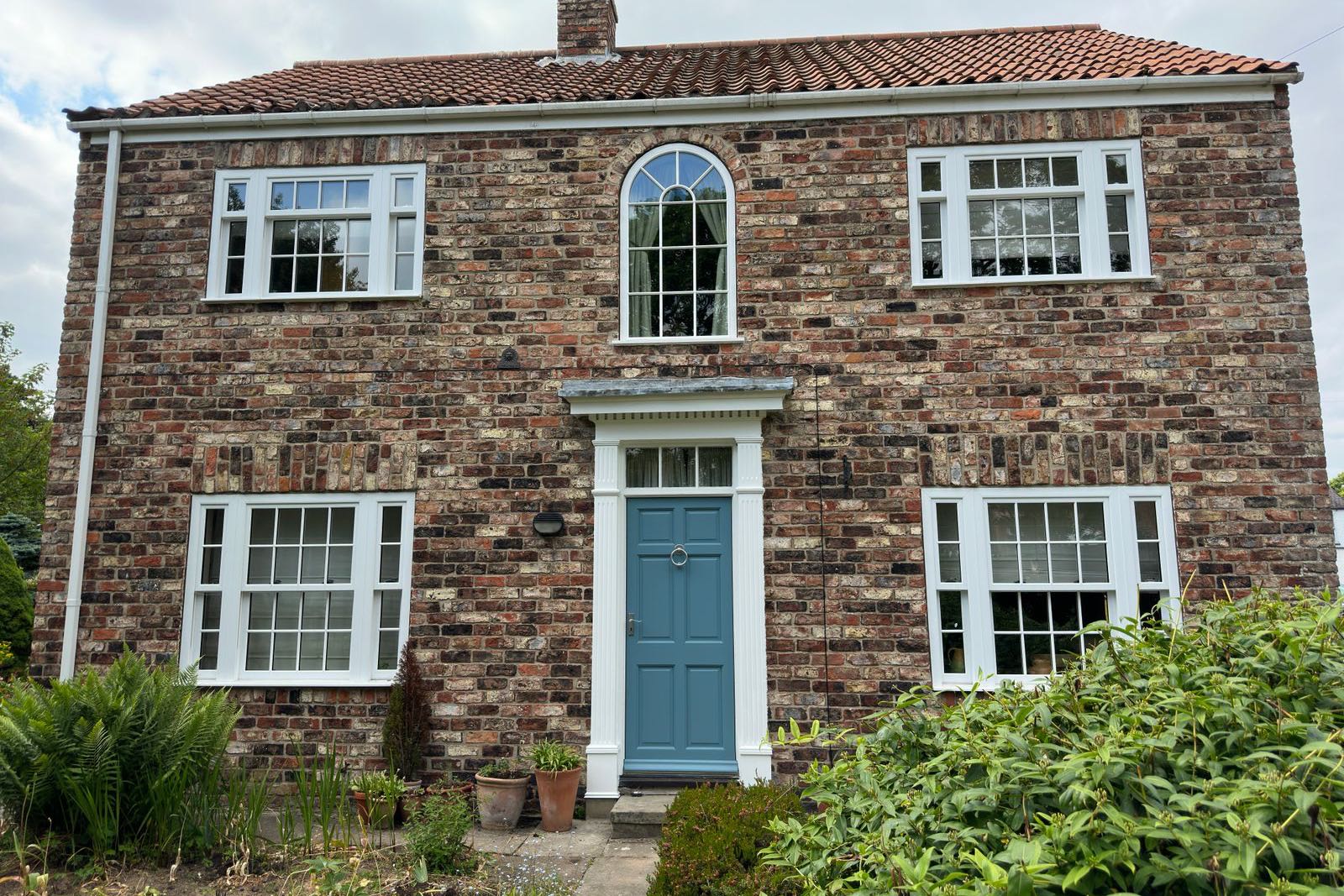 An ordinary UK house with a blue front door