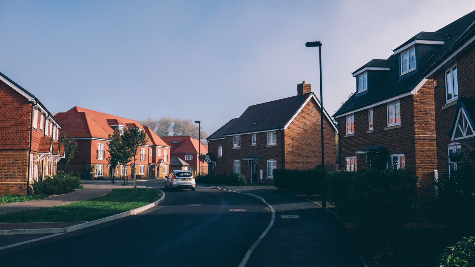 Morning light on a street of red-brick semi-detached houses