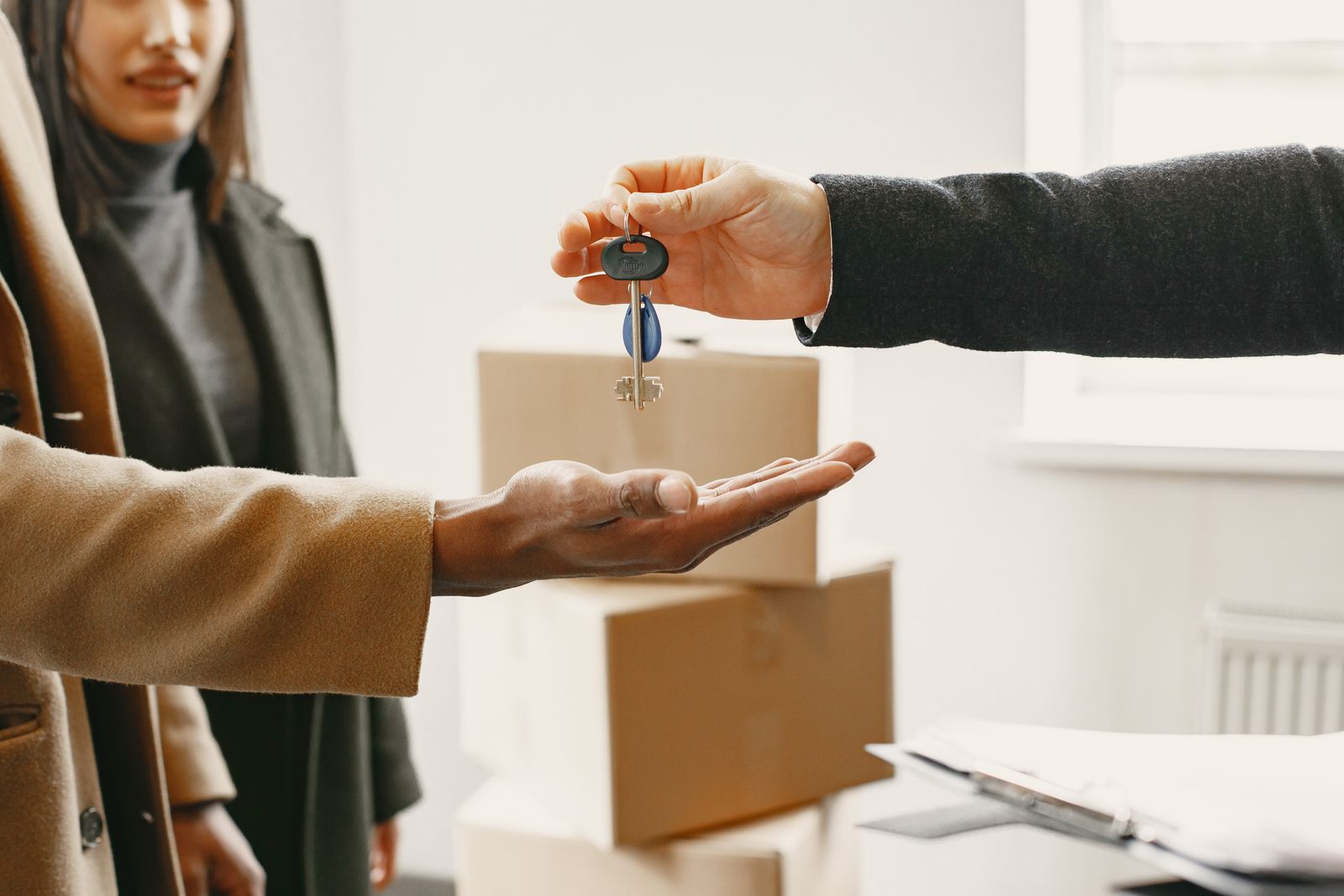 House keys being handed over amid moving boxes